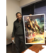 Man poses with movie poster for Black Lightning