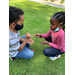 children sitting down playing rock paper scissors