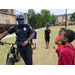 policeman walking with a bike talking to children