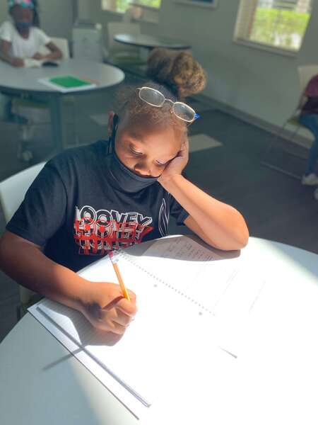 girl writing notes in a notebook