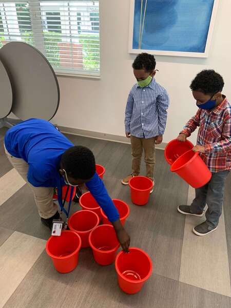 three boys playing with buckets