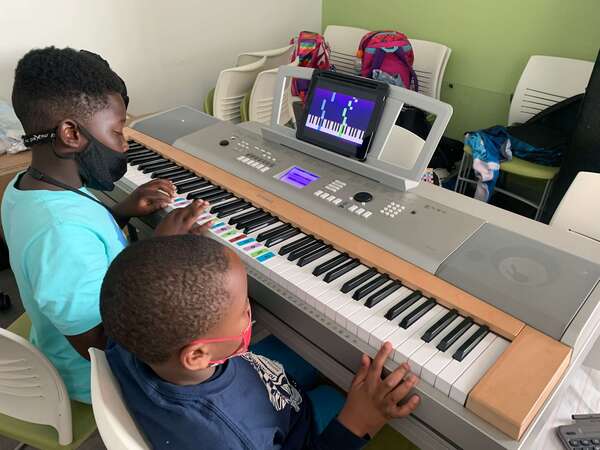 two boys playing the piano