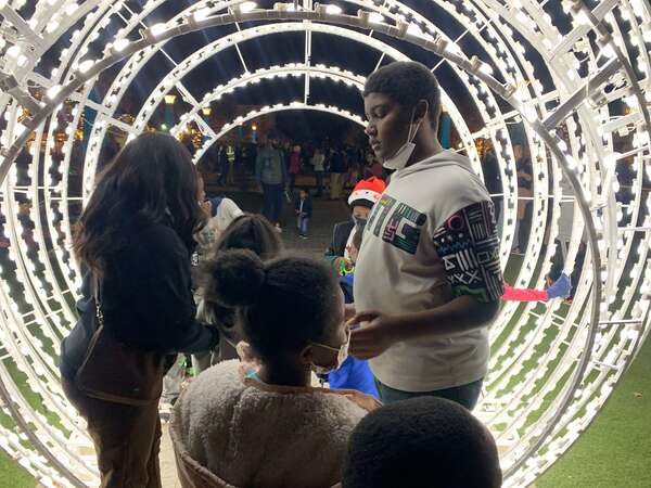 children standing next to christmas lights