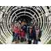 children standing as a group in the middle of bright christmas lights