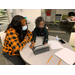 young girl using laptop with older woman