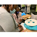 woman helping young girl make crafts