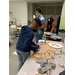 young boy using hot glue gun at a table