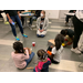 children sitting on the floor by an older woman talking