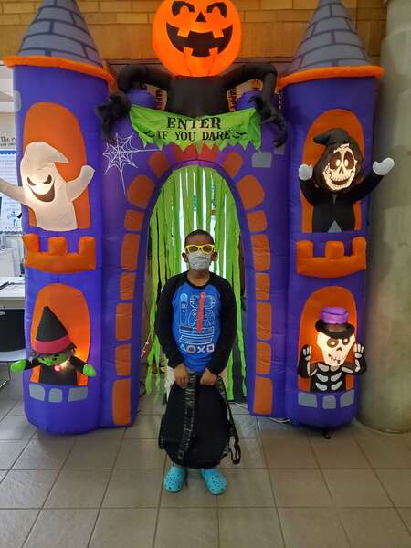 boy standing in front of halloween decorations