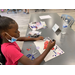 a girl using a glue stick to make crafts