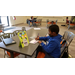 a boy drawing while sitting at a table