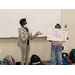 two girls standing next to each other holding a sign